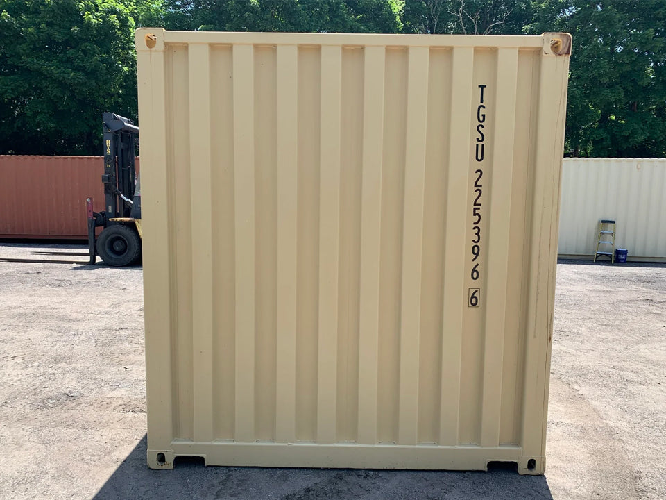 Front view of a new shipping/storage container, showcasing its tan exterior and identification number.